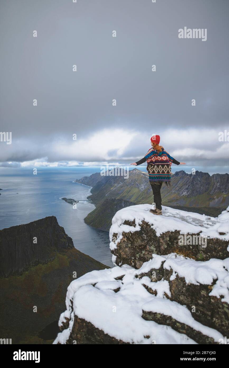 Junge Frau in rotem Hut und Pullover auf verschneiten Berg Stockfoto
