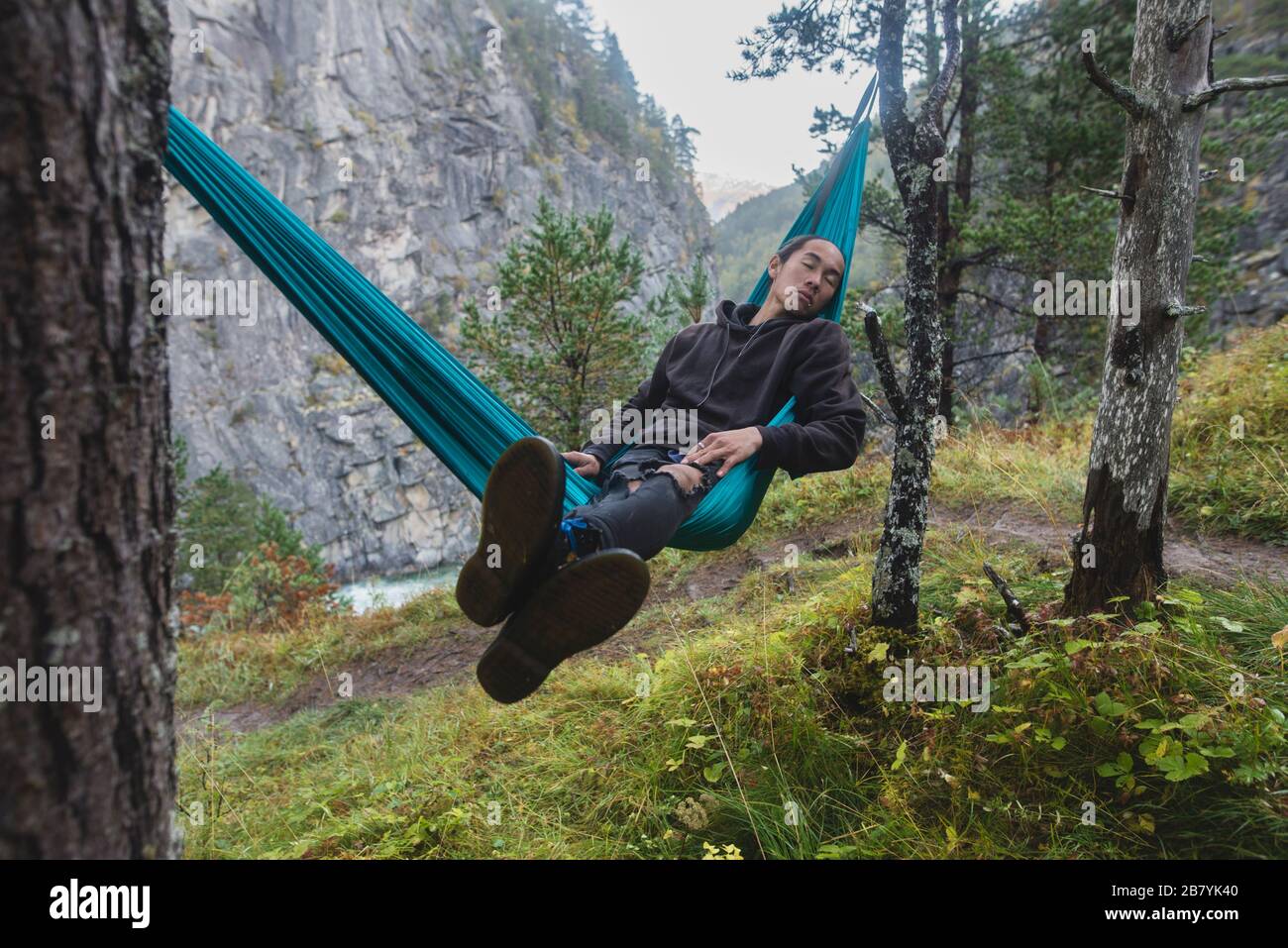 Junger Mann, der in der Hängematte ruht Stockfoto