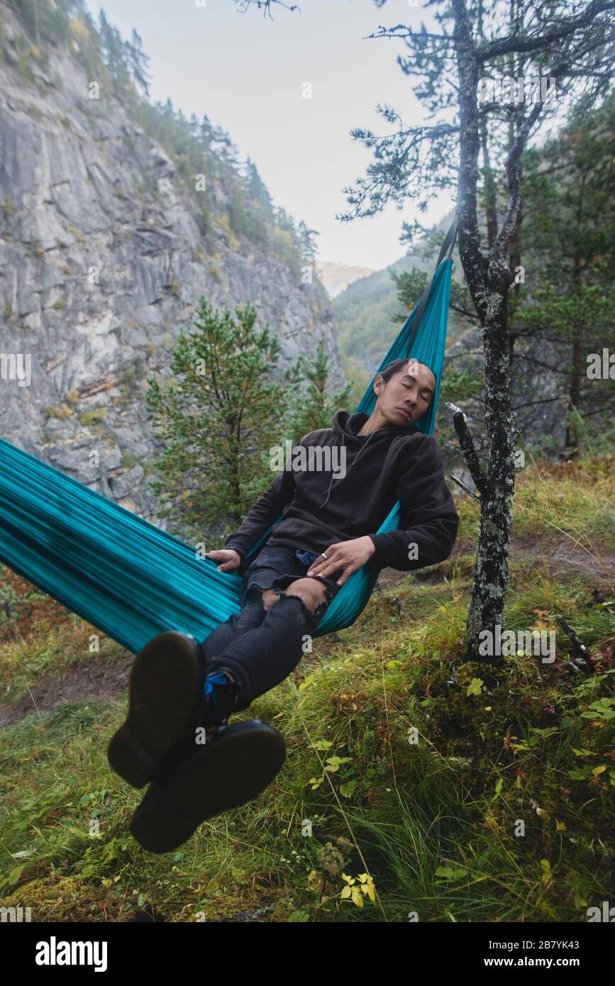 Junger Mann, der in der Hängematte ruht Stockfoto