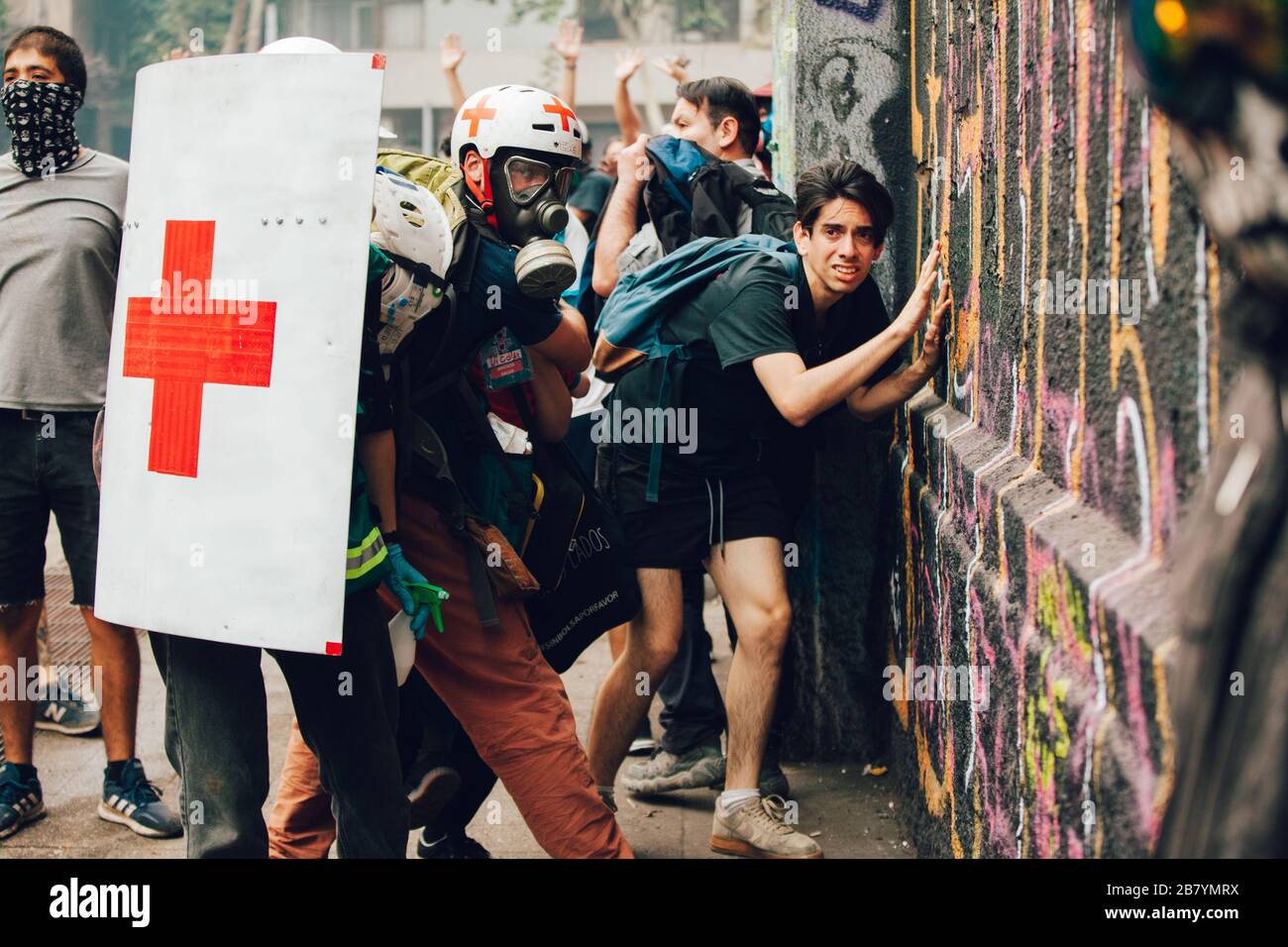SANTIAGO, CHILE - 8. NOVEMBER 2019 - Freiwillige des Roten Kreuzes schützen während der Proteste-ag Zivilisten vor Polizisten und Projektilen von Demonstranten Stockfoto