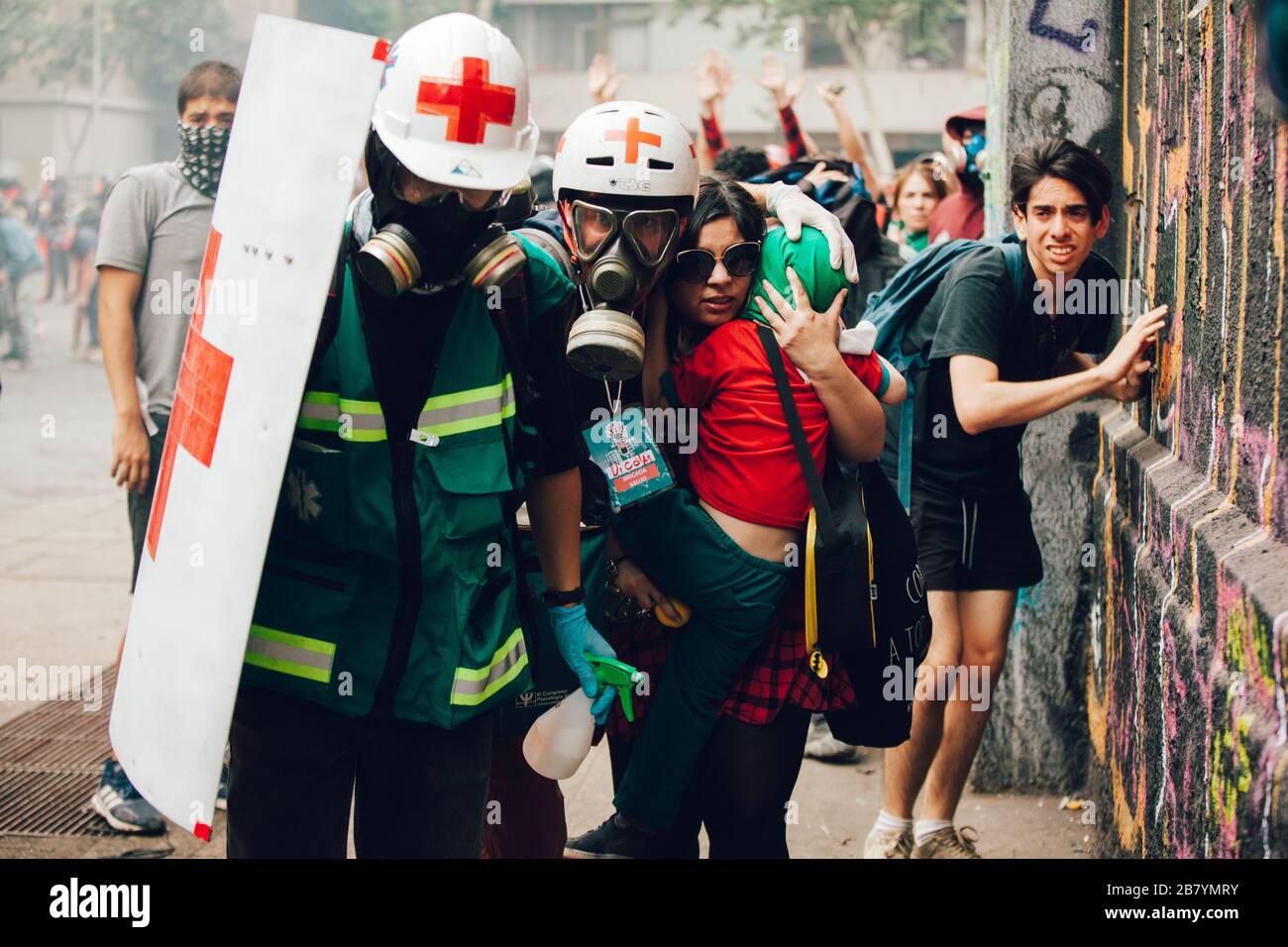 SANTIAGO, CHILE - 8. NOVEMBER 2019 - Freiwillige des Roten Kreuzes schützen während der Proteste-ag Zivilisten vor Polizisten und Projektilen von Demonstranten Stockfoto