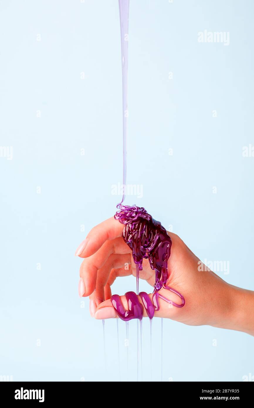 Süße Karamellpaste für die violette Farbe an der weiblichen Hand, Touch Sensative kreative Idee, Haarentfernungskonzept, Kosmetikindustrie, Banner-Flyer c Stockfoto