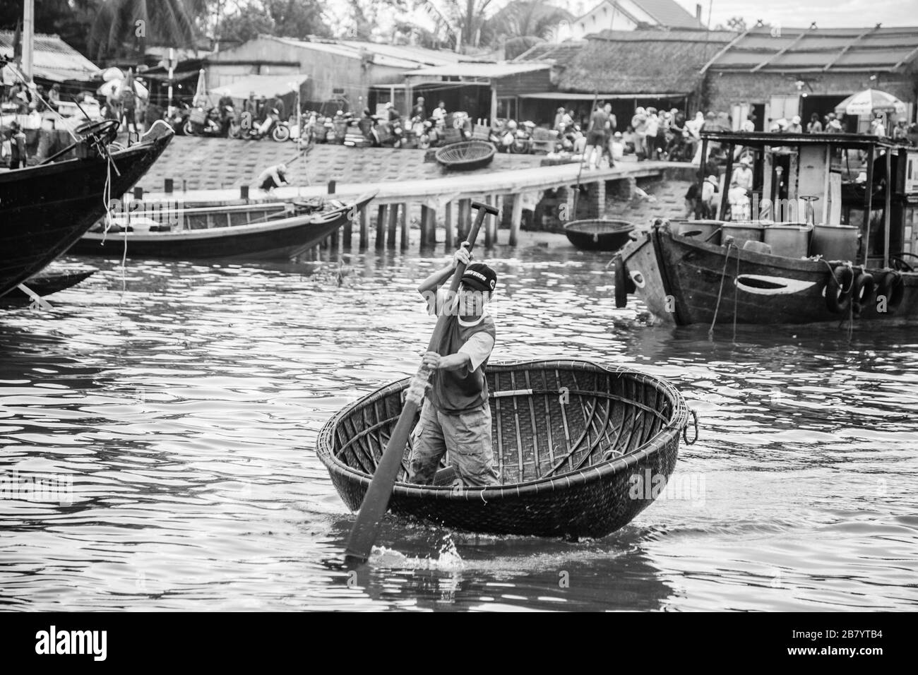 Lächelnder Fischer im traditionellen vietnamesischen Korbboot Stockfoto
