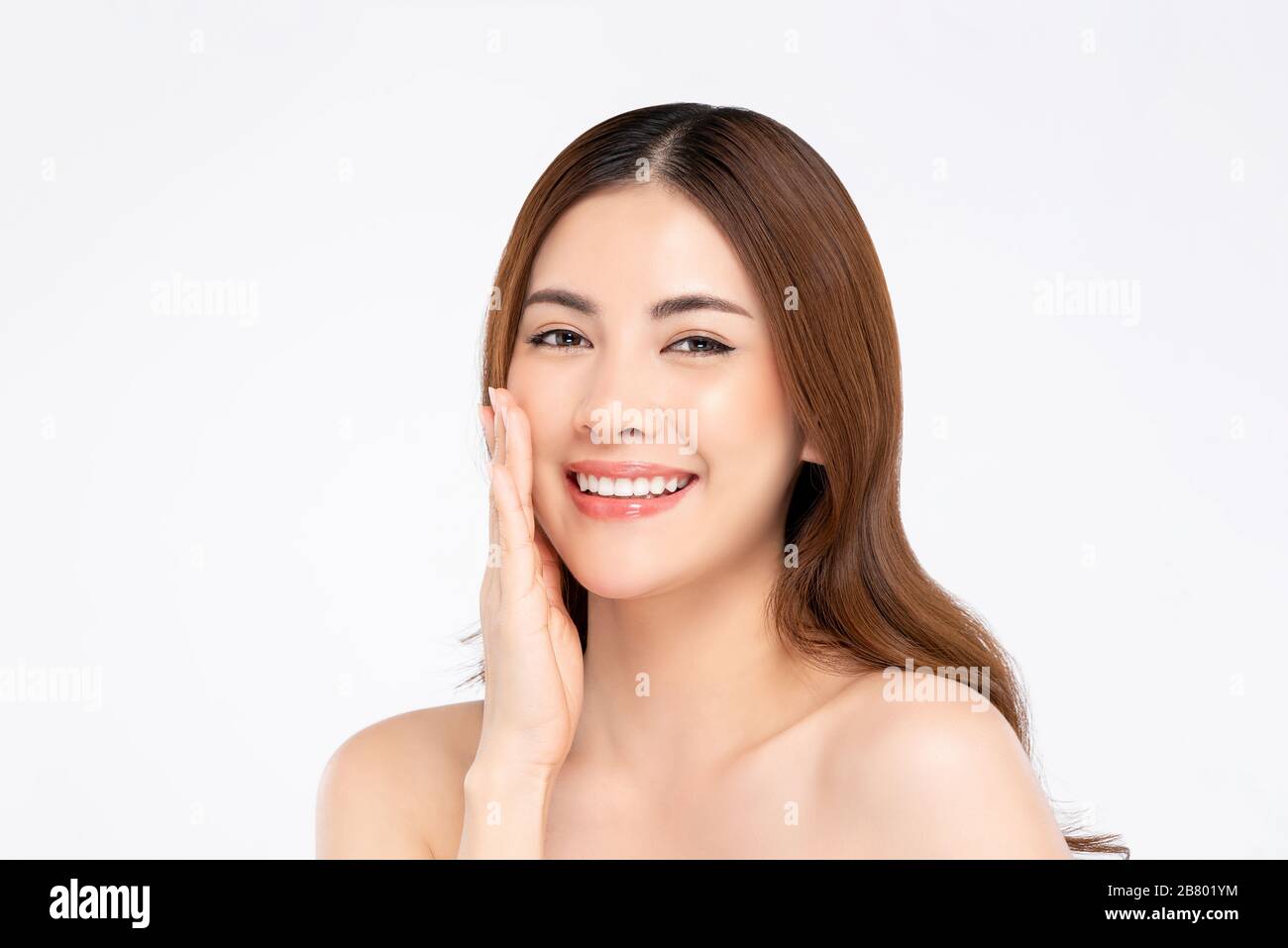 Schönheitsaufnahme eines lächelnden asiatischen Frauenmodells mit klarer fairer Haut, die Hand berührt Gesichtspose in weiß isoliertem Hintergrund für Hautpflegekonzept Stockfoto