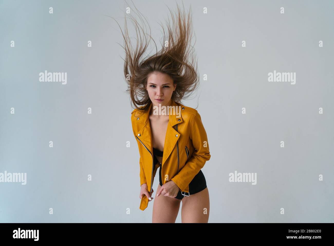 Junges faires Mädchen mit langen, fliegenden Haaren im Studio, Weitwinkelobjektiv und Blick auf die Kamera. Stockfoto