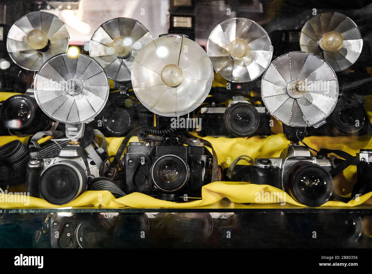 Alte Blitzreflektoren mit Klapplüfterkamera mit Blitzlampen an alten Kameras mit geringer Schärfentiefe. Stockfoto