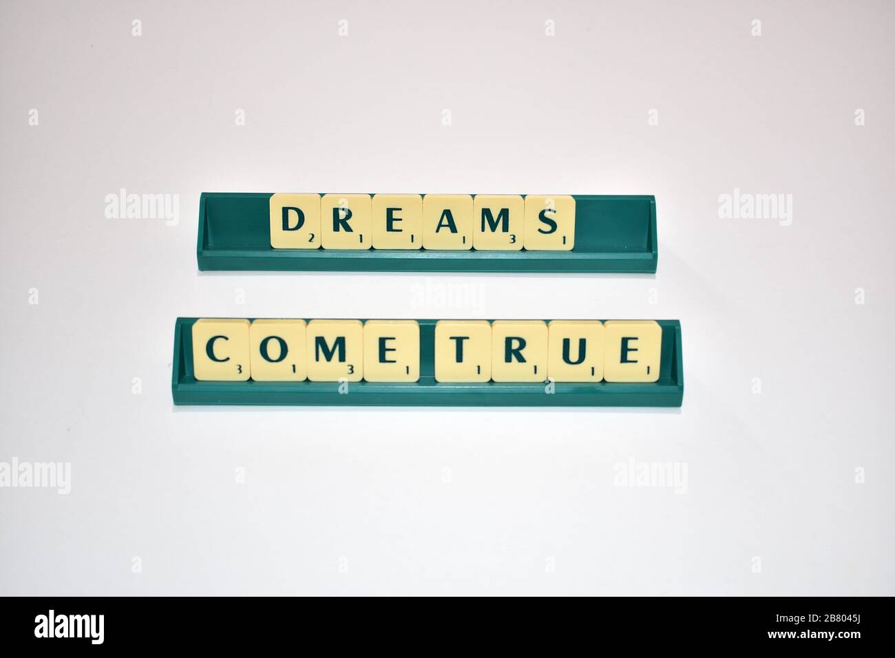 Scrabble Tiles Spell Out Dreams Come True. Motivationszitat Scrabble blockiert Briefe Grauer Hintergrund Lebenszitat induzieren Alphabet. Stockfoto