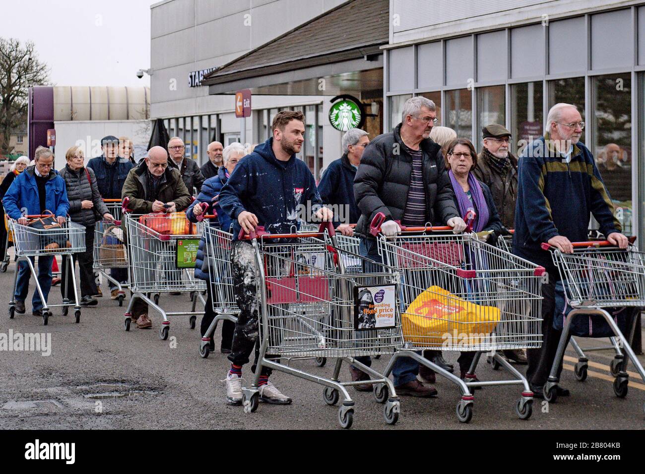 Die Leute warten darauf, in Sainsbury's Supermarket in Leamington Spa, Warwickshire zu kaufen, wo der Laden angekündigt hatte, dass die erste Stunde der Eröffnung für ältere und verletzliche Kunden stehen würde. Stockfoto