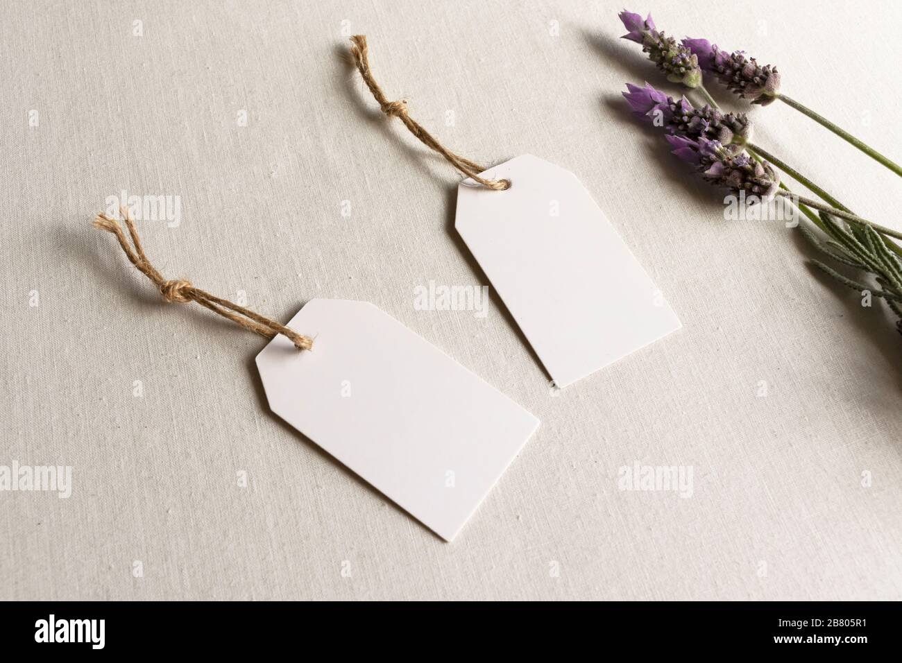 Leerer Geschenkanhänger - zwei weiße Geburtstagsketten für die Hochzeit mit Lavendel und Garn Stockfoto