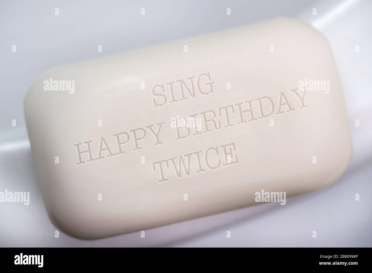 Eine Seifenleiste mit den Worten Sing Happy Birthday zweimal, UK Coronavirus Konzeptbild. Stockfoto