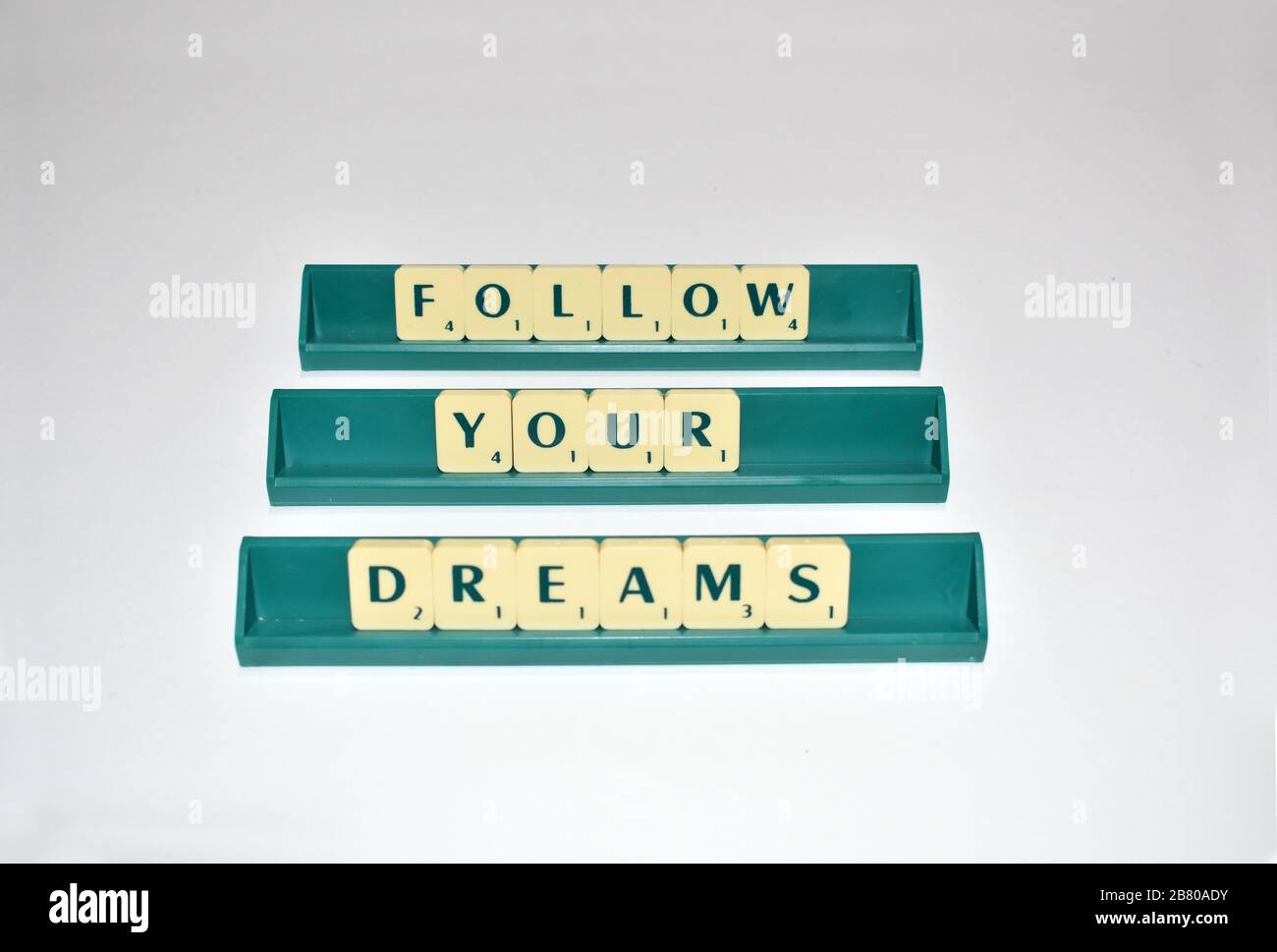 Scrabble Tiles Spell Out Follow Your Dreams. Motivationszitat Scrabble blockiert Briefe Grauer Hintergrund Lebenszitat induzieren Alphabet. Stockfoto