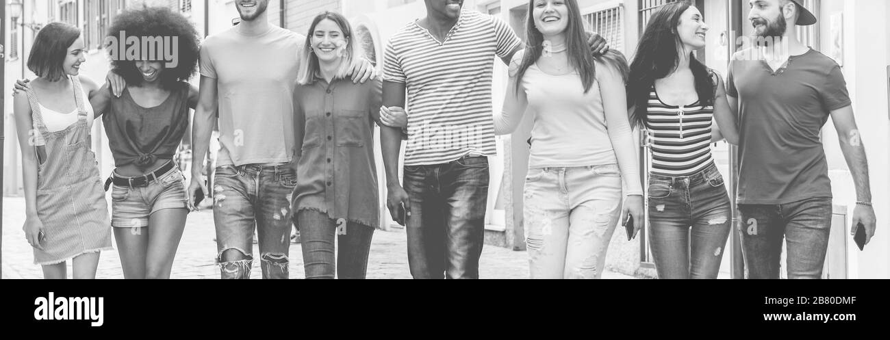 Fröhliche millenniale Freunde, die in der städtischen Innenstadt spazieren gehen - junge Leute, die gemeinsam Spaß haben - Jugend-Lifestyle und Freundschaftskonzept - konzentrieren sich auf Mittelsleute Stockfoto
