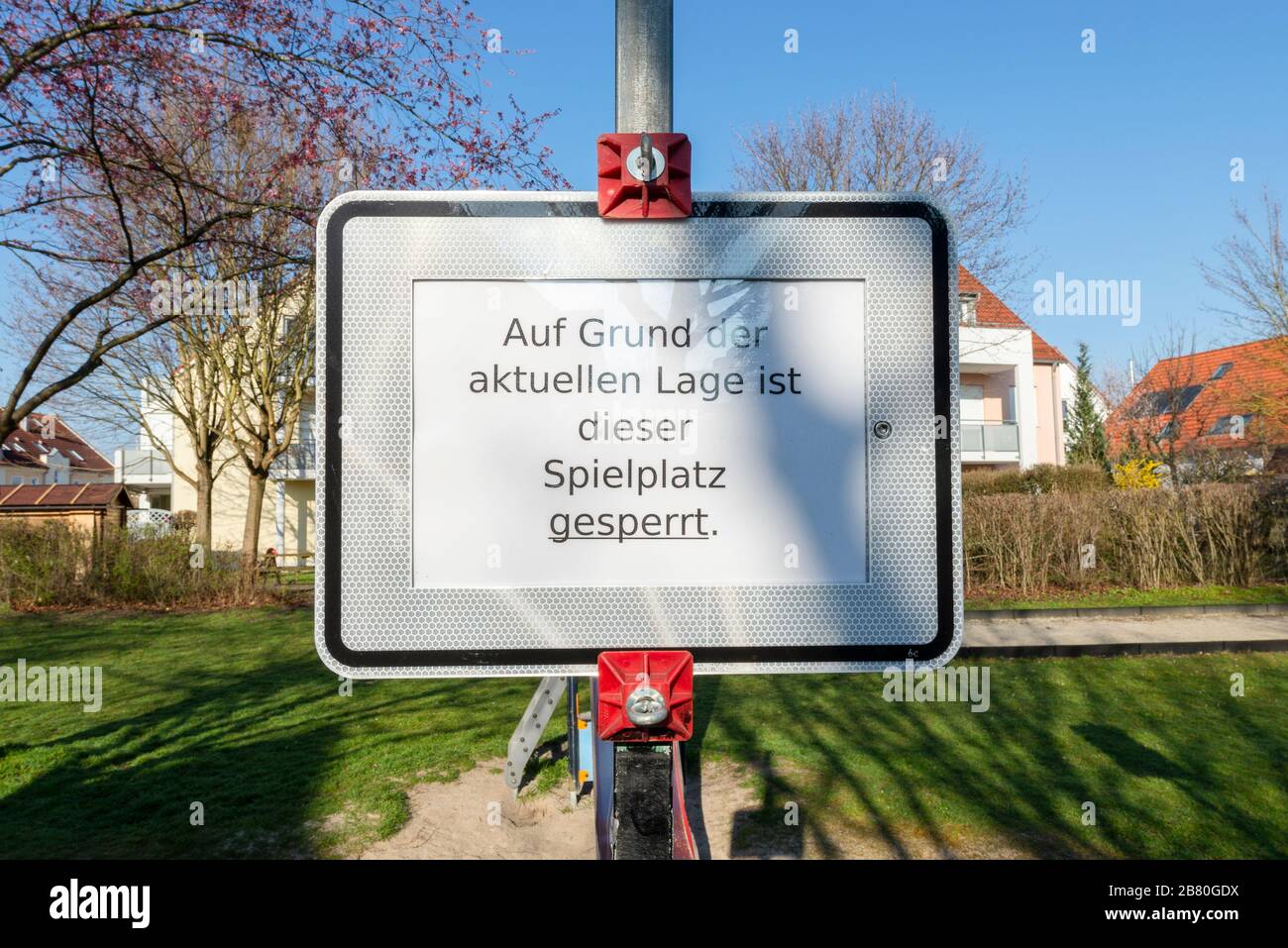Verbotsschild und rot-weißes Absperrband an einem verschlossenen Kinderspielplatz während der Corona-Krise in Deutschland Stockfoto