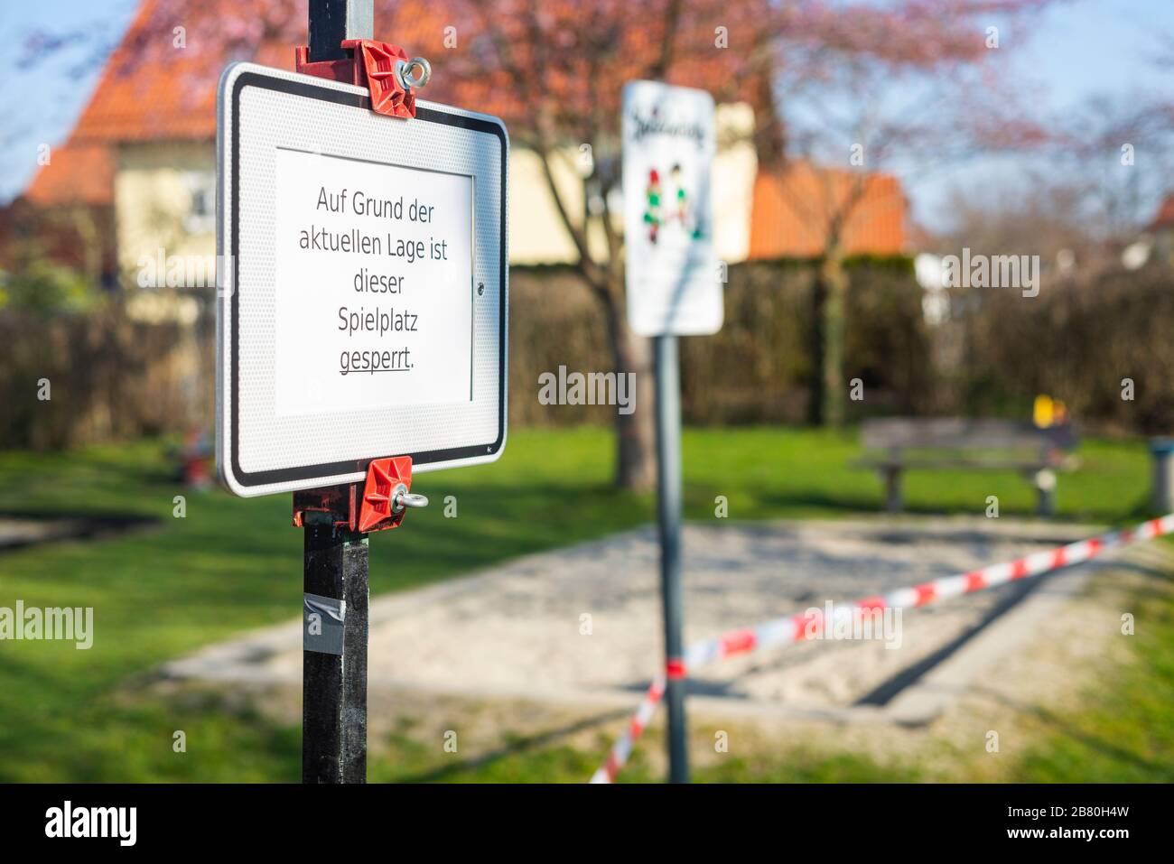 Verbotsschild und rot-weißes Absperrband an einem verschlossenen Kinderspielplatz während der Corona-Krise in Deutschland Stockfoto