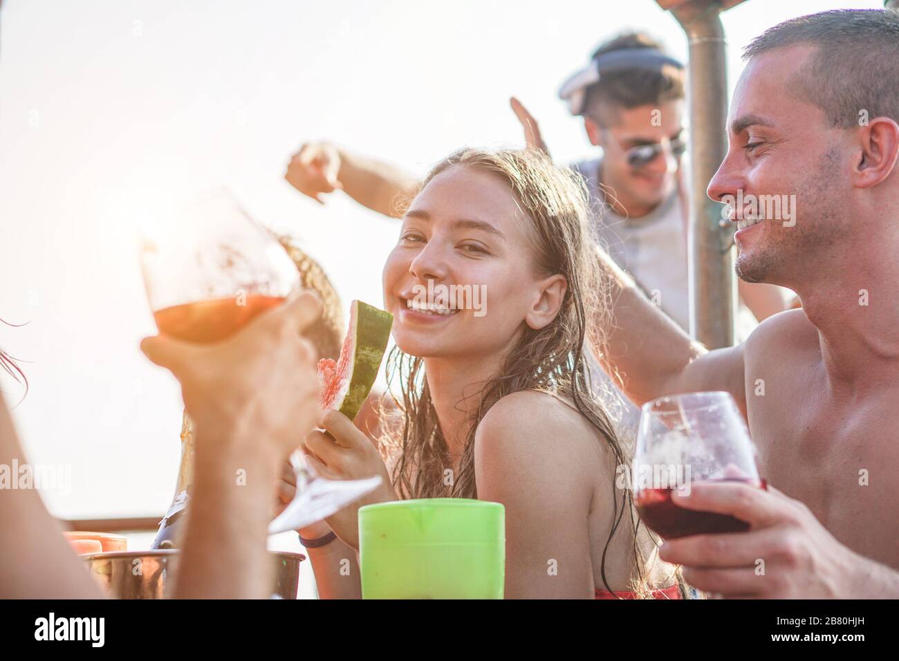 Fröhliche Freunde, die auf der Bootsparty Sangria-Rotwein trinken und Wassermelonen essen - junge Leute, die im Sommerurlaub Spaß haben - Jugend, Freundschaft und Trave Stockfoto