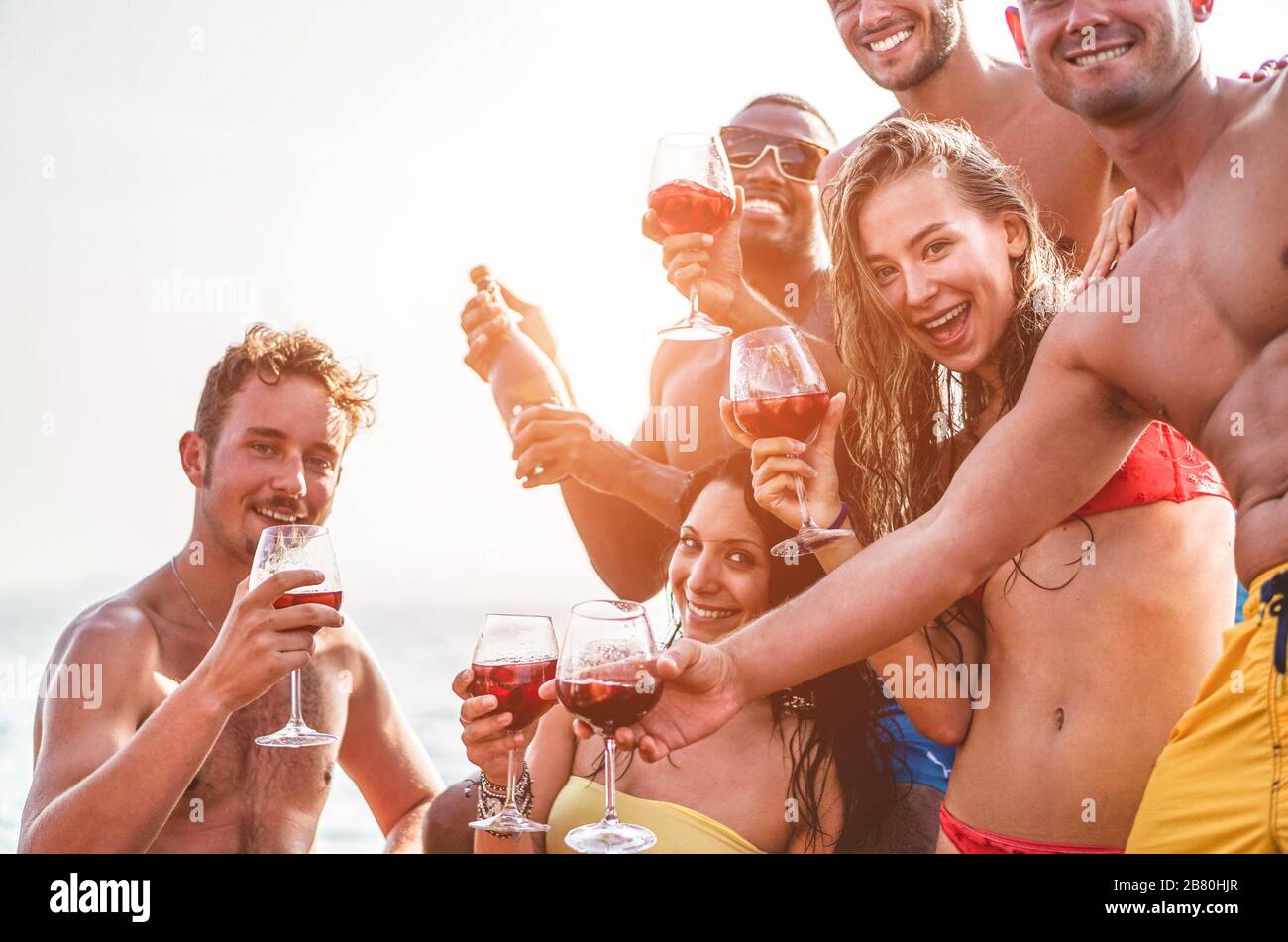 Fröhliche Freunde, die auf der exklusiven Bootsparty Sangria-Wein trinken - junge Leute haben Spaß im Sommerurlaub - konzentrieren sich auf die richtige blonde Frau - Reisen, Freund Stockfoto