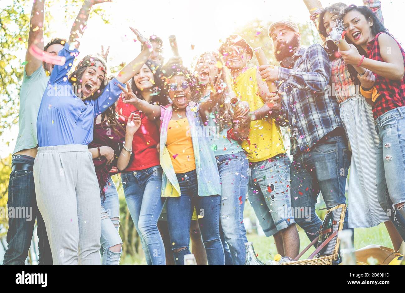 Fröhliche Freunde, die Party machen, Konfetti im Freien werfen - junge Studenten lachen und feiern zusammen - Jugend-Lifestyle, Millennials Generation und Stockfoto