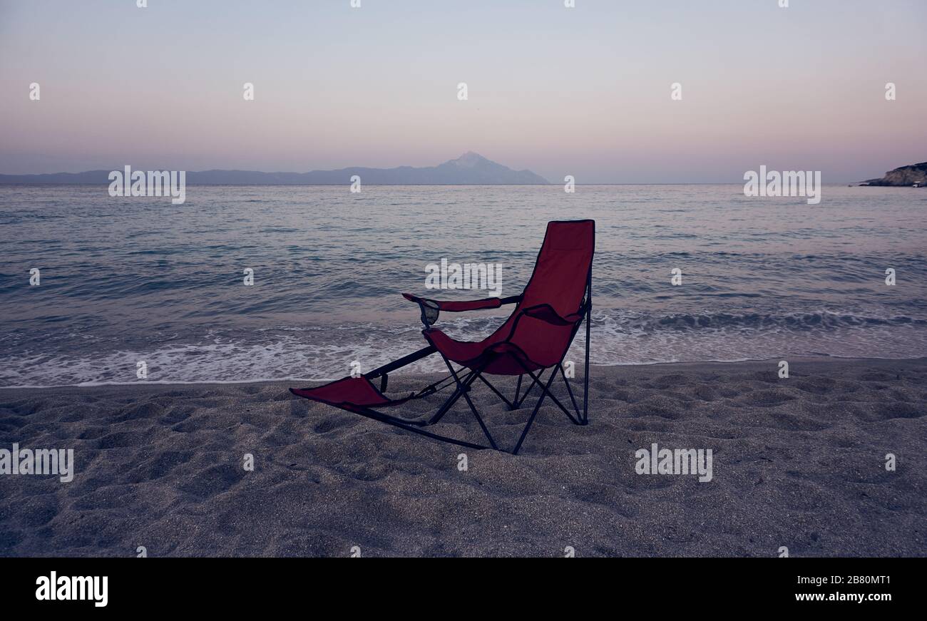 Camping-Stuhl am Meer bei Sonnenuntergang Stockfoto