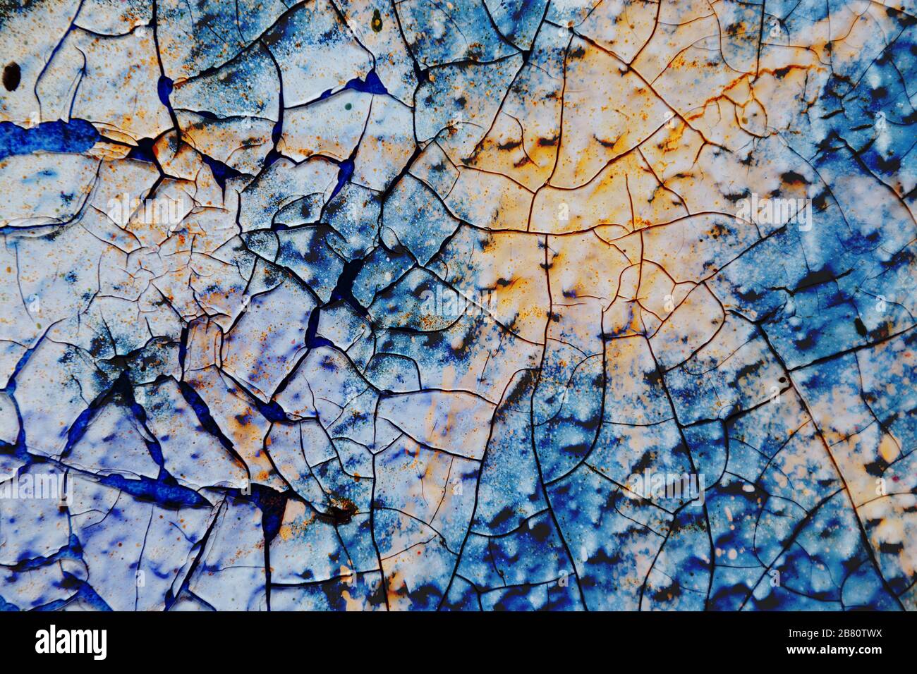 Oberflächentextur mit blauer und gelber Farbe auf einer Oberflächenstruktur mit dickem Lack und mit Rissen. Für abstrakte Hintergründe. Deutschland Stockfoto