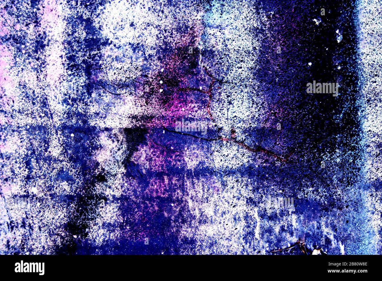 Oberflächenbeschaffenheit mit Rest blauer und violetter Farbe auf Betonoberfläche mit Rissen. Für abstrakte Hintergründe. Deutschland Stockfoto
