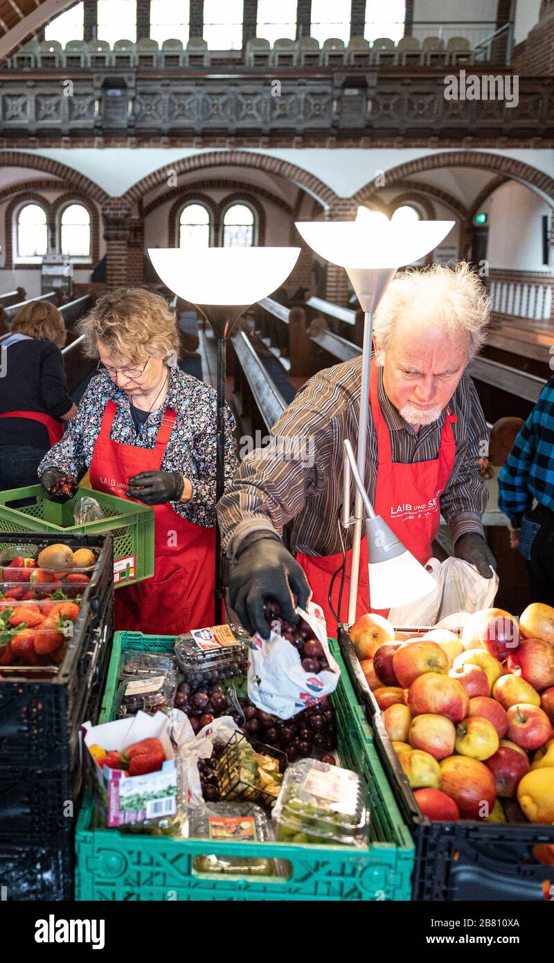 Berlin, Deutschland. März 2020. Freiwillige aus "Laib und Seele", einer Kampagne der Berliner Tafel, des RBB und der Kirchen, sortieren Lebensmittelpakete für Bedürftige in der Passionskirche. Die Berliner Tafel versucht mit einem Krisenplan, die Unterstützung für Bedürftige während der Coronavirus-Pandemie fortzusetzen. Credit: Fabian Sommer / dpa / Alamy Live News Stockfoto