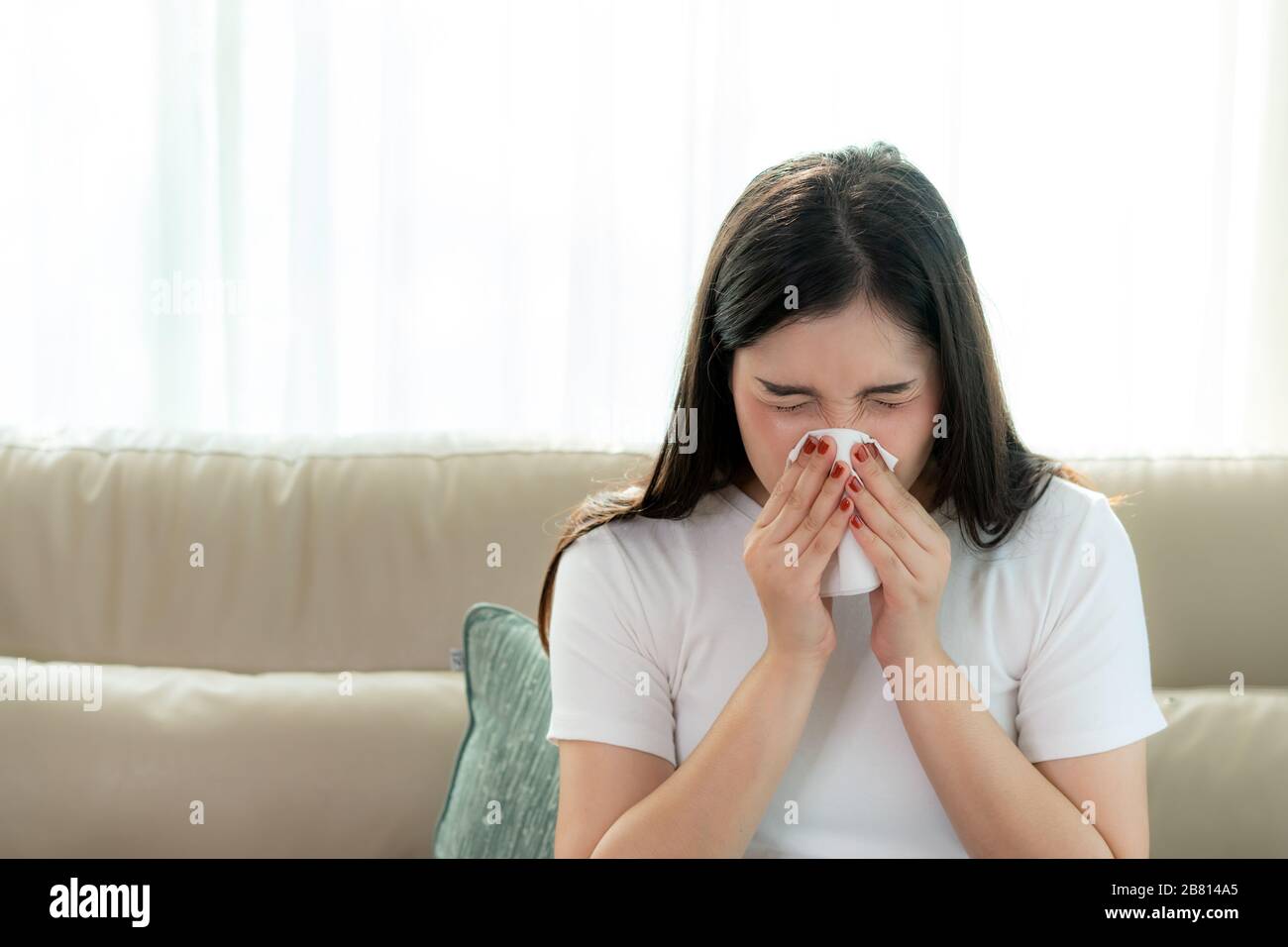 Asian Woman krank und traurig mit Niesen an der Nase und kaltem Husten auf Gewebepapier, weil Influenza und schwache oder Virusbakterien von Staubwetter oder Rauch Stockfoto