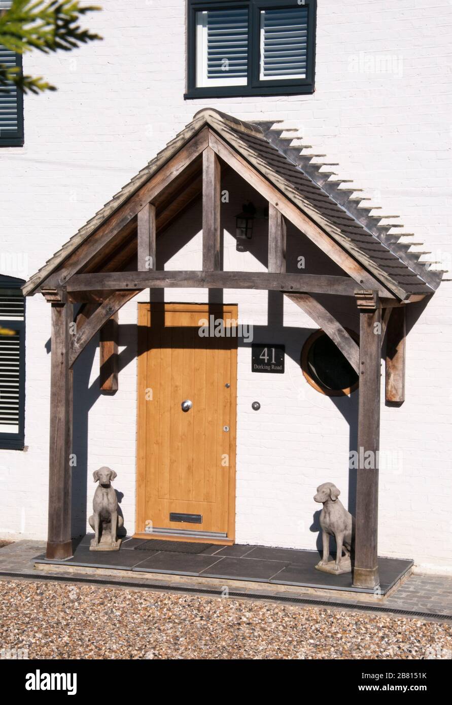 Eingang zu einem Haus in Great Bookham, Surrey, England, mit kaninischen Statuetten, die auf beiden Seiten der Eingangstür platziert sind Stockfoto
