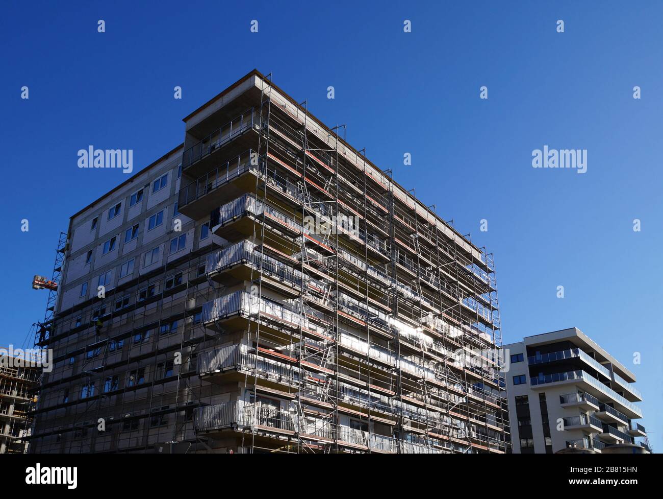 Bau von Häusern, letzte Bauphase. Gerüste um Gebäude herum. Stockfoto