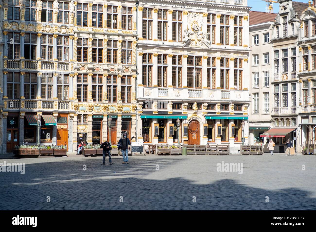 Ein Nachrichtenteam befindet sich auf dem nahezu leeren Grand Place in Brüssel und berichtet von der enormen Leere, nachdem die Regierung strengere Sperrvorschriften eingeführt hat Stockfoto