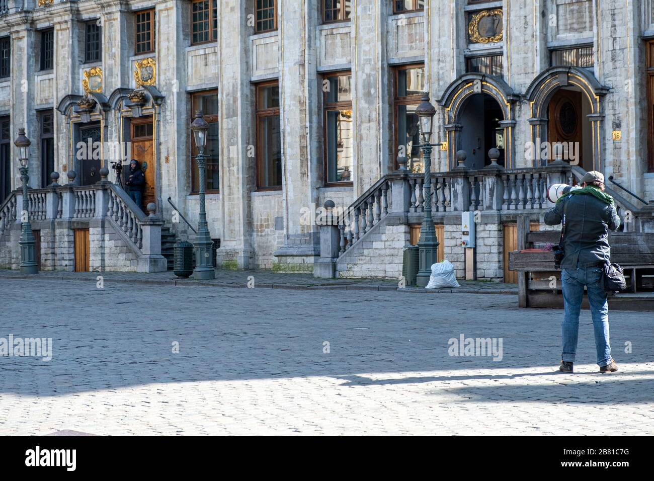 Ein Fotograf nimmt Bilder auf, ein anderer scheint den Grand Place kurz nach Mittag zu Filmen, wenn neue strengere Einschränkungen stattfinden Stockfoto