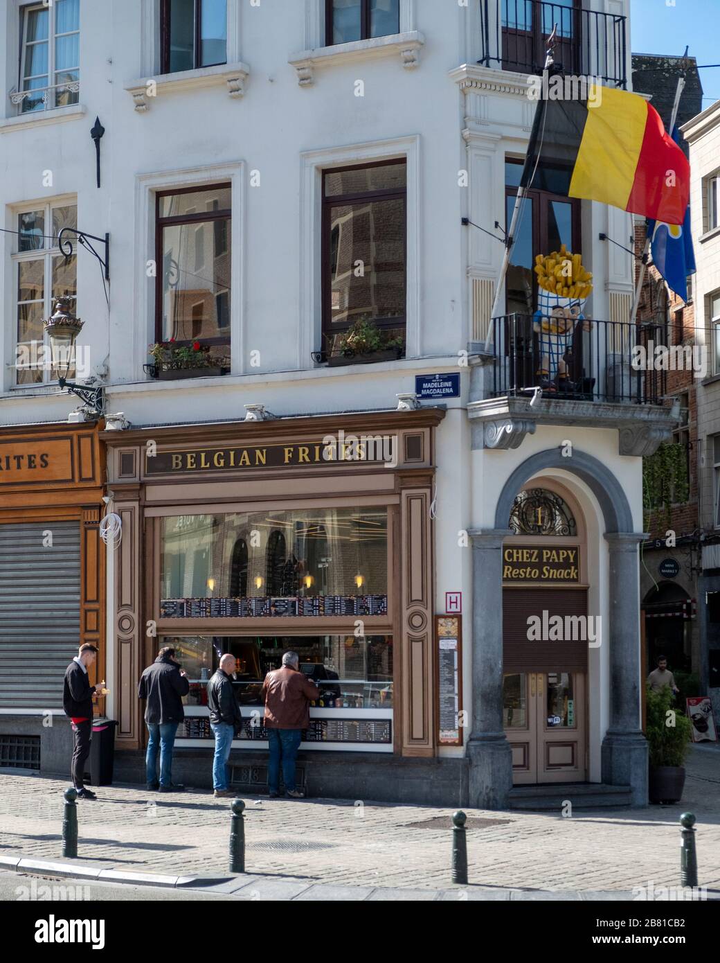 Leute, die Pommes frites in einer berühmten Friterie in brüssel kaufen. Die Regeln der sozialen Distanzierung werden noch nicht eingehalten. Vertikales Bild Stockfoto