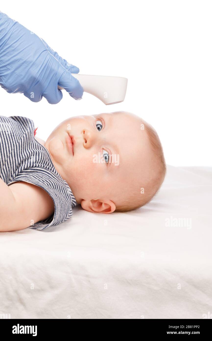 Kinderarzt oder Krankenschwester überprüft die Körpertemperatur des Jungen mithilfe eines Infrarot-Stirnthermometers (Thermometerpistole) auf das Symptom einer Krankheit Stockfoto