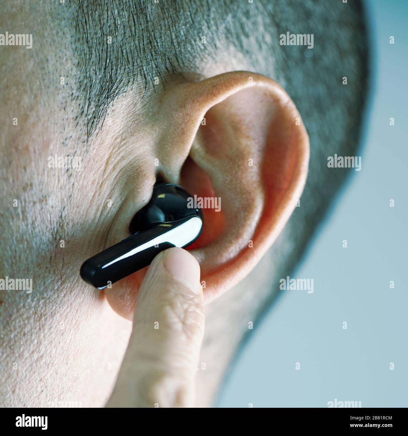 Nahaufnahme eines kaukasischen Mannes mit drahtlosen Ohrhörern Stockfoto