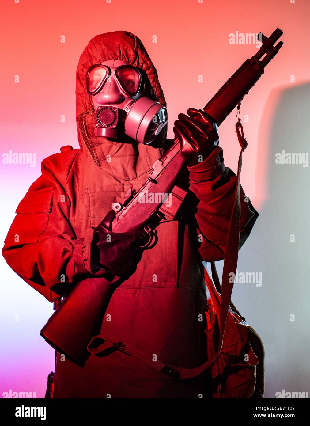 Mann im chemischen Kampfanzug und Maske, das Gewehr hält Stockfoto