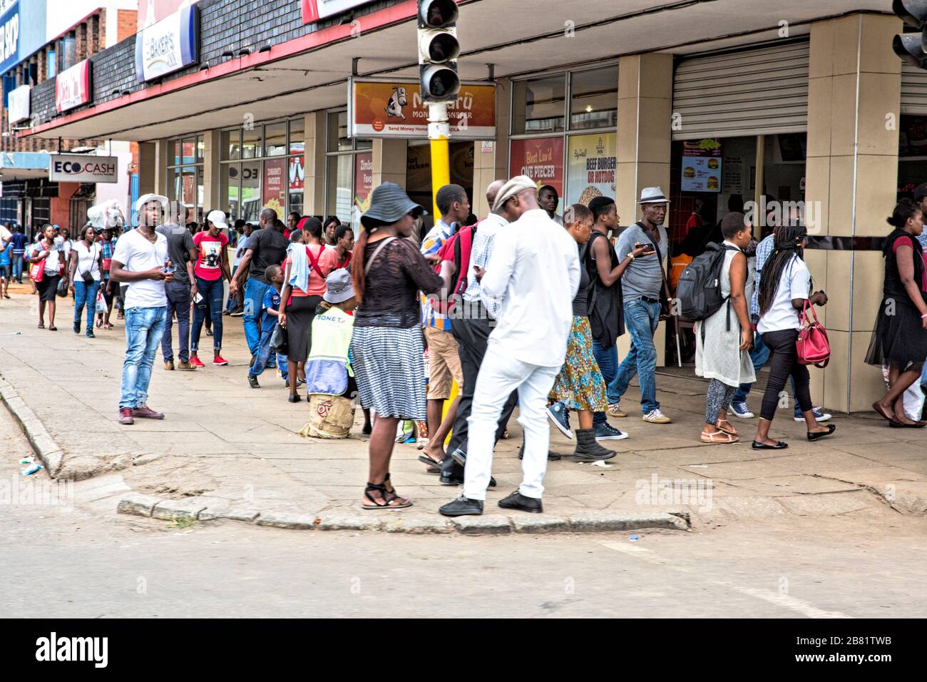 Lange Schlange von Leuten, die Schlange stehen, um in den Laden zu kommen. Warteschlangen sind in Harare zur Norm geworden. Stockfoto