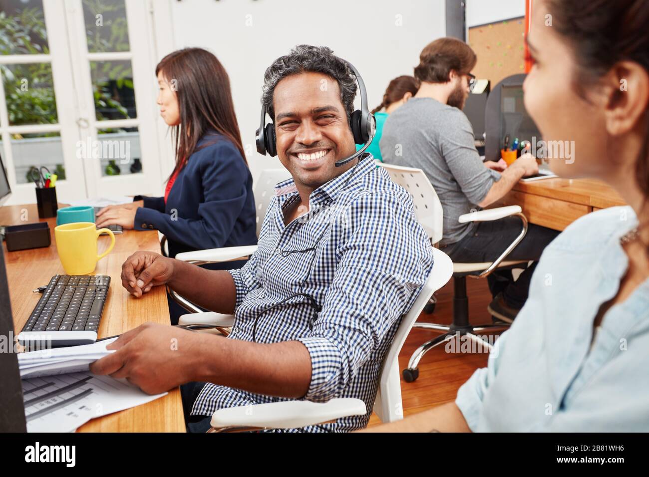 Lächelnder Mann in Indien arbeitet im Callcenter als Kundenservice Stockfoto