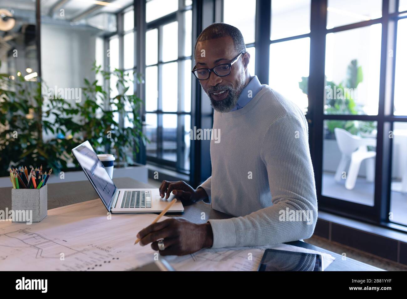 Afroamerikanischer Mann, der im modernen Büro arbeitet Stockfoto