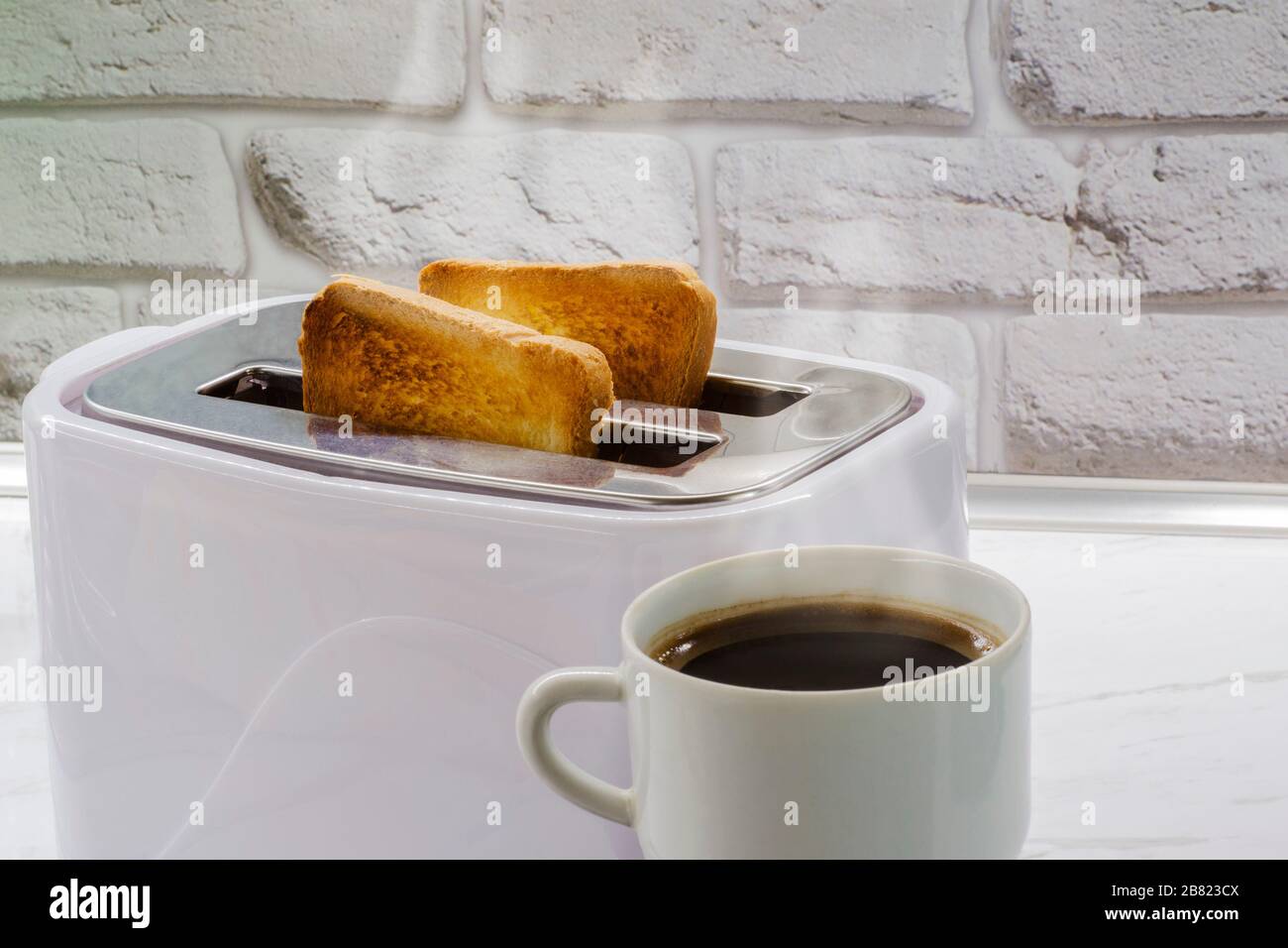 Eine Tasse Kaffee und Toast in einem Toaster Stockfoto