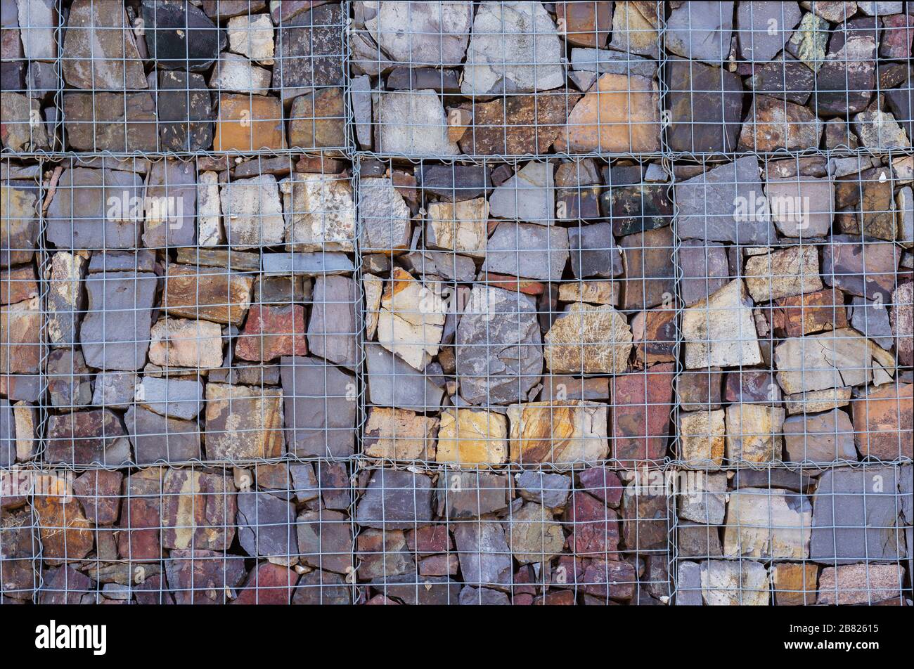 Wand aus Steinen hinter dem Gitter Stockfoto