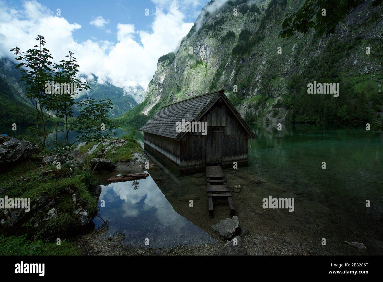 Holzhütte/Bootshaus am Obersee, umgeben von Bergen in Schönau am Koenigssee in den bayerischen Alpen, Nationalpark Berchtesgaden, Deutschland Stockfoto