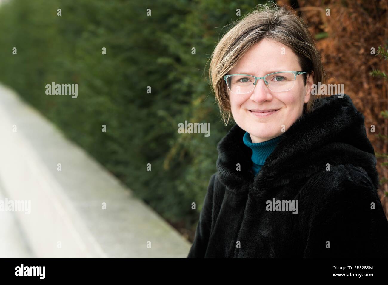 Attraktive dreißig Jahre alte Frau posiert in Winterkleidung Stockfoto