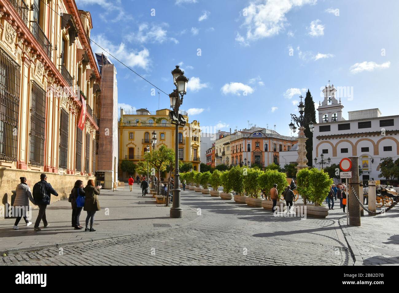 Touristen, die auf einem Platz in Sevilla spazieren gehen Stockfoto