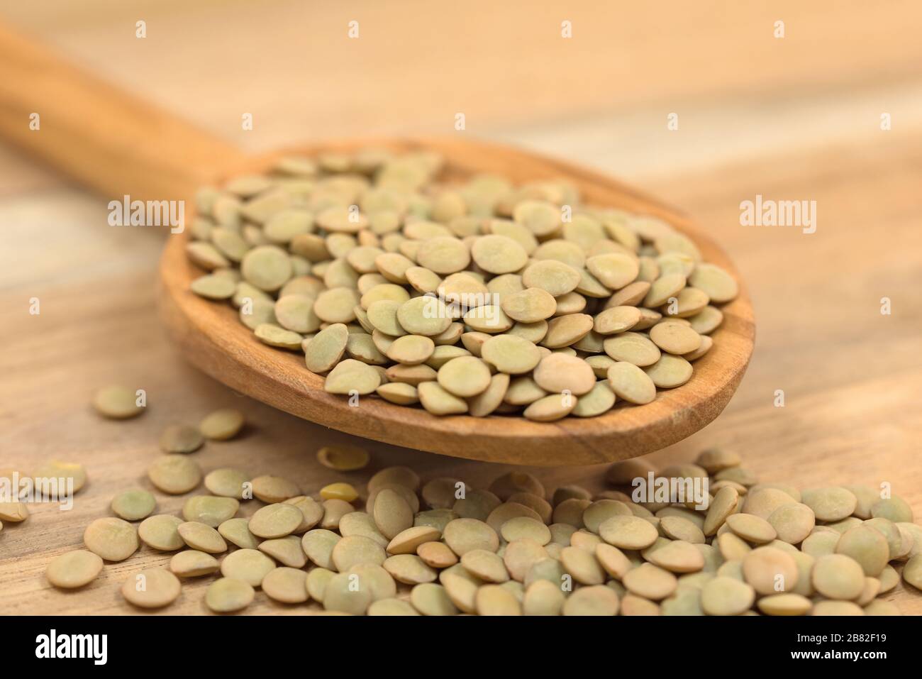 Linsen auf einem Holzlöffel Stockfoto