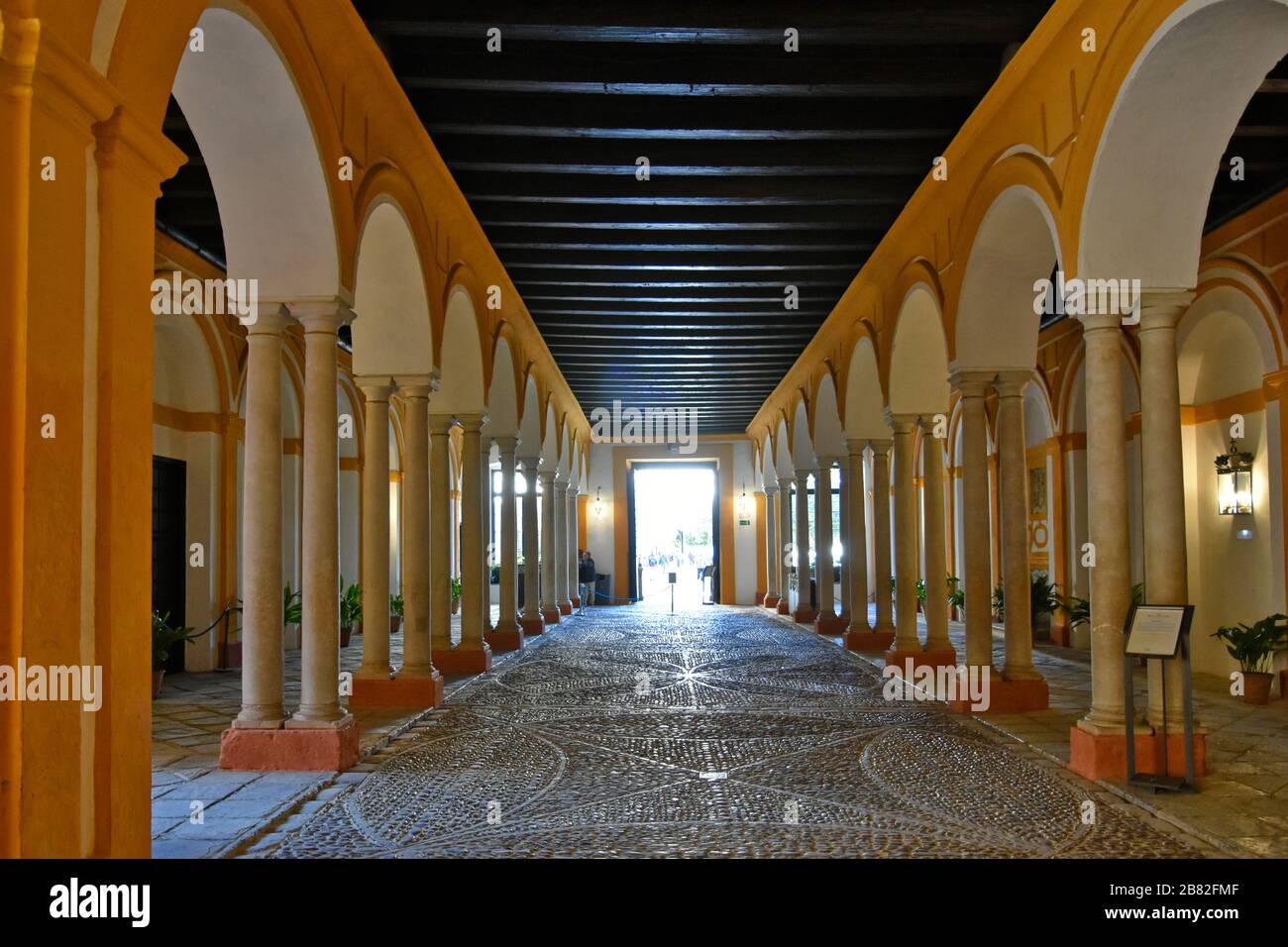 Ein Korridor mit Bögen im Alcazar-Gebäude in Sevilla Stockfoto