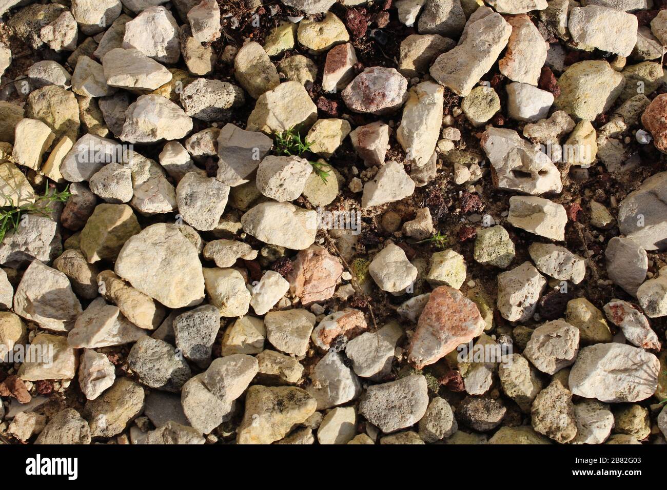 Bunte Felsen im Schmutz können als Tapete verwendet werden. Stockfoto