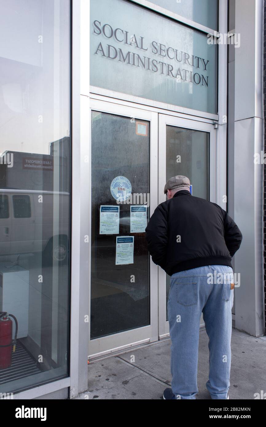 Ein Mann liest Schilder, die in seinem örtlichen Sozialversicherungsamt veröffentlicht wurden, und gibt an, dass es aufgrund des Coronavirus oder der Kovid-19-Pandemie geschlossen ist Stockfoto