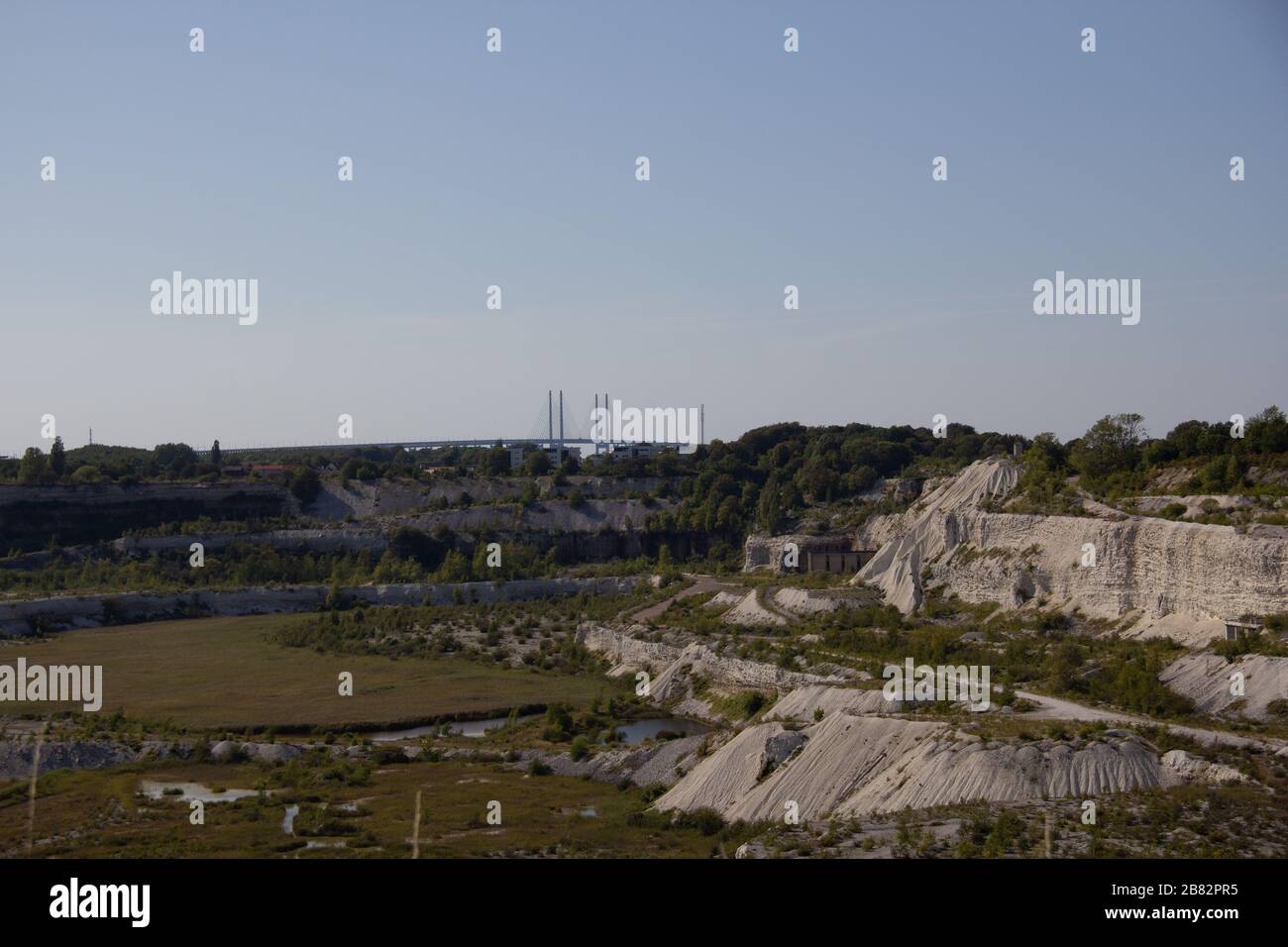 Der riesige Kalksteinbruch, eine Narbe im Boden, wird nicht mehr genutzt. Stattdessen ist es ein Schutzgebiet in Malmö, Schweden. Die Oresundbrücke ist sichtbar Stockfoto