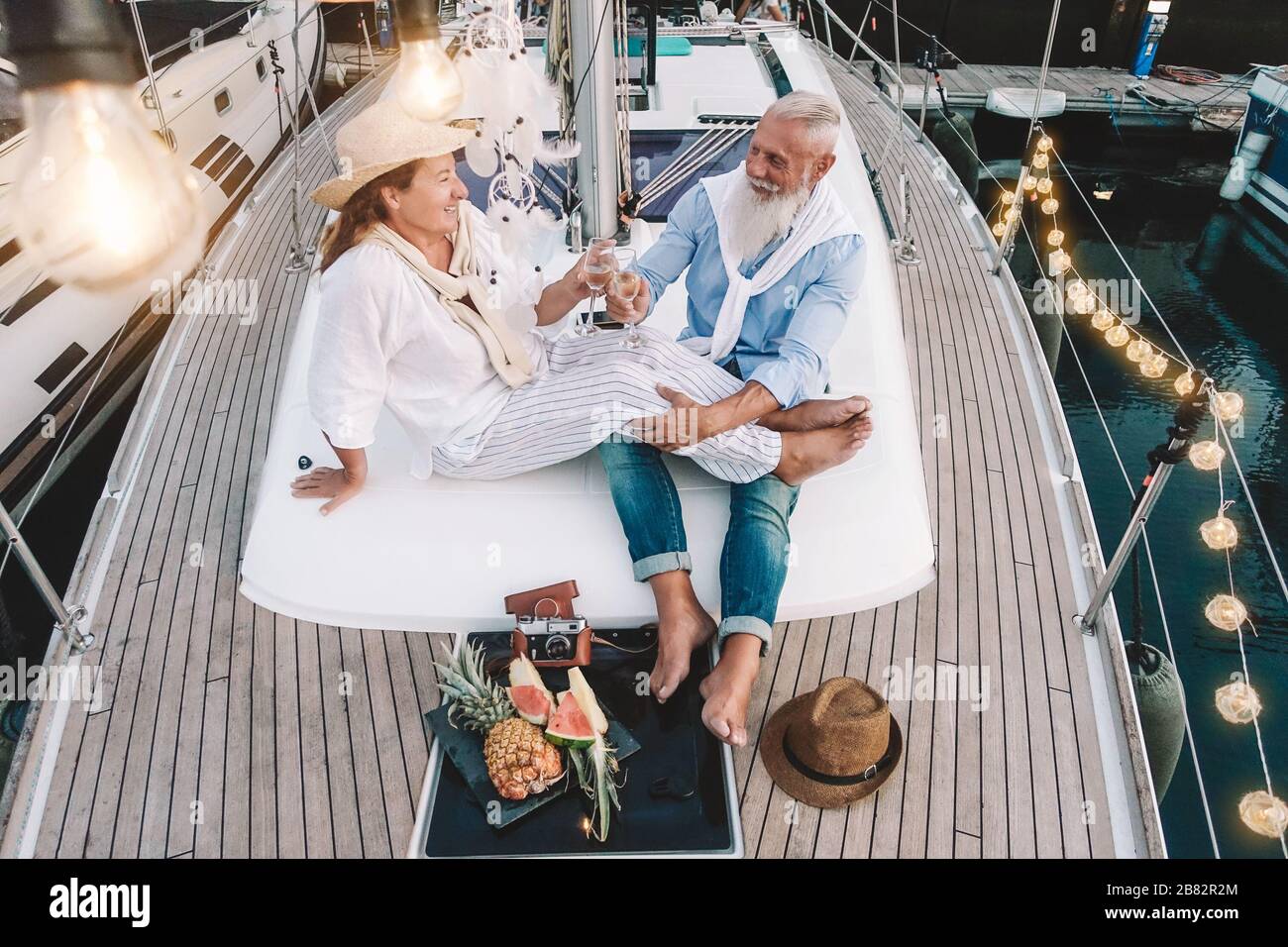 Älteres Paar, das Champagner auf segelschiffurlaub toastet - Glückliche, reife Leute, die Spaß haben, Hochzeitstag auf Bootsfahrt zu feiern Stockfoto