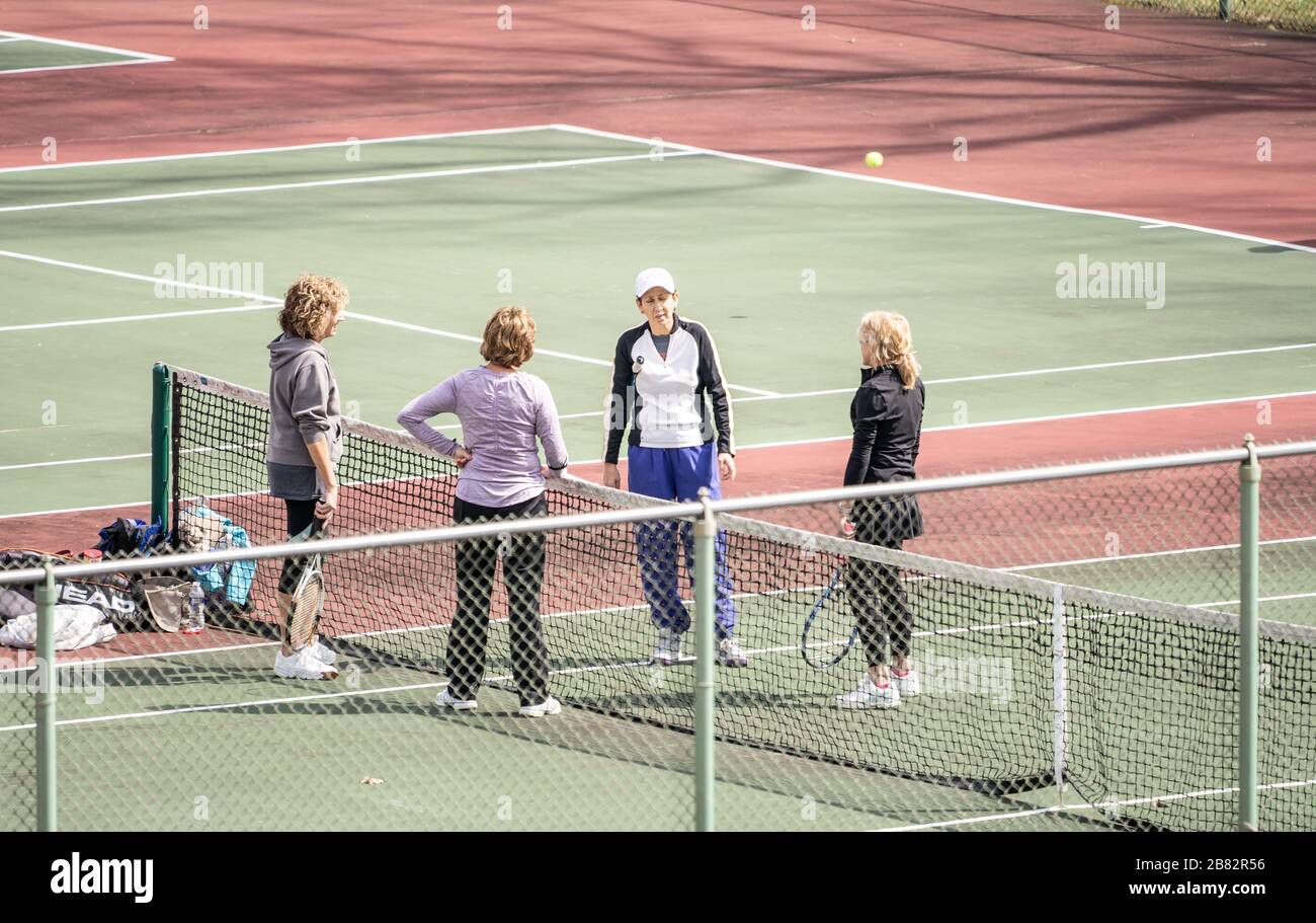 Eine Gruppe von Frauen, die am warmen Frühlingstag Tennis spielen. Stockfoto