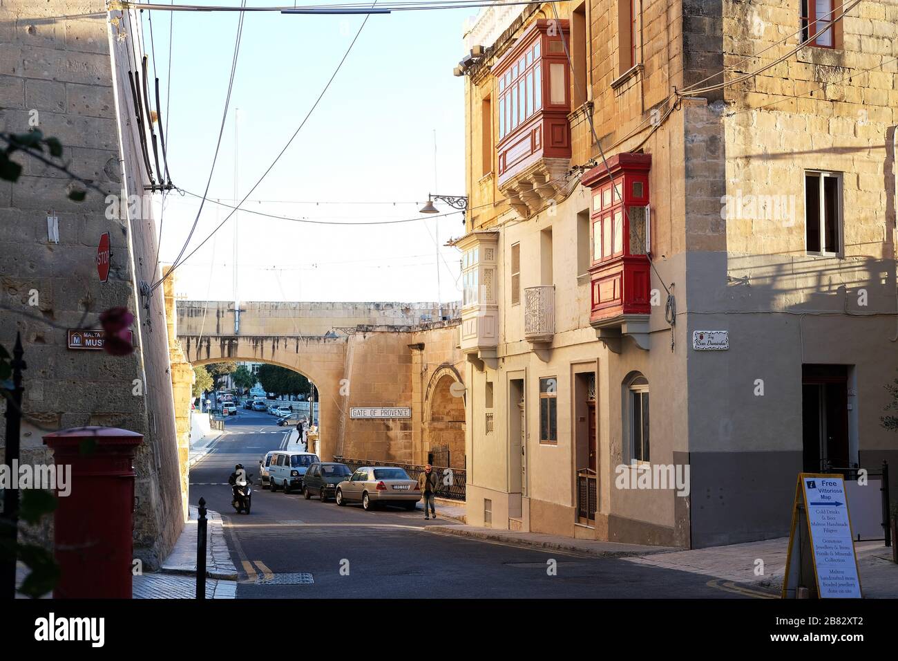 Birgu, Malta 02/07/2020 Mann, der bei Sonnenuntergang auf der alten maltesischen Straße ein Moped fährt Stockfoto